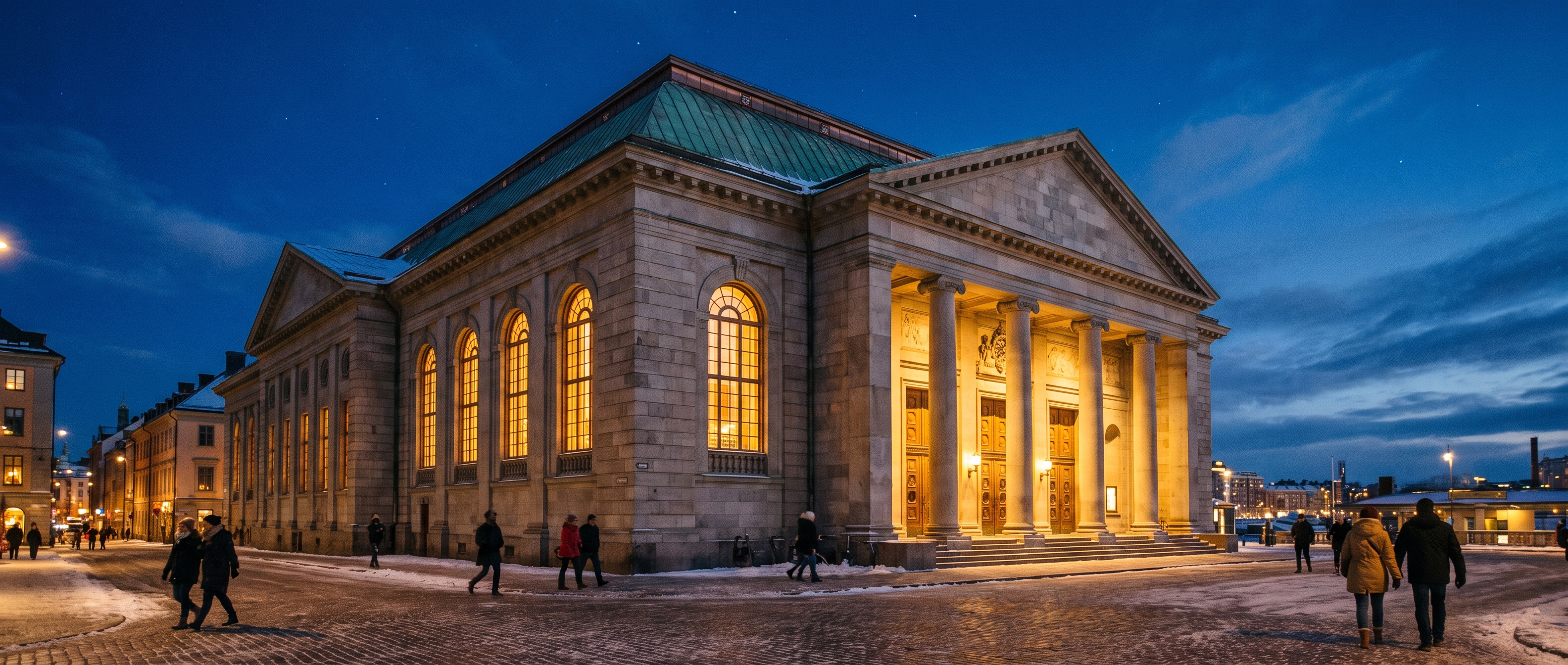 Concert hall exterior at night with warm light spilling from entrance